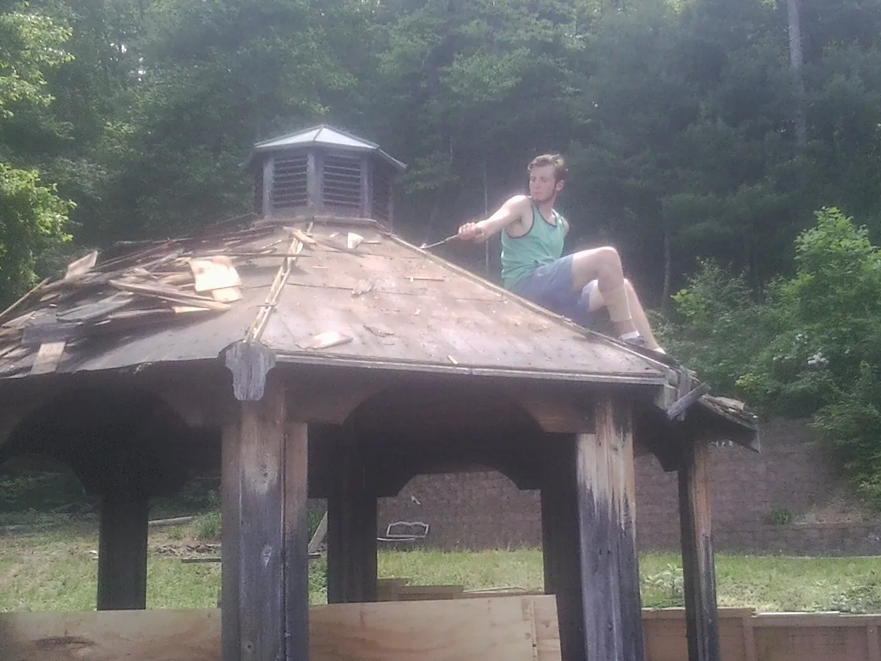 Tearing the old roof off a wooden gazebo before new shakes in Thornton